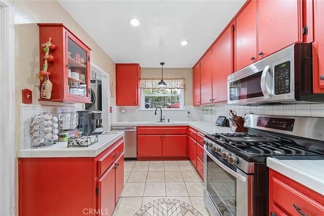 4303 E De Ora Way, Long Beach, CA 90815 - kitchen featuring stainless steel appliances, red cabinetry, decorative backsplash, tile countertops, and recessed lighting