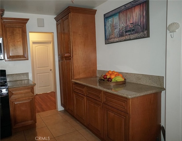 8937 Palmetto Ave, Fontana, CA 92335 - kitchen with light tile patterned flooring, brown cabinetry, and appliances with stainless steel finishes