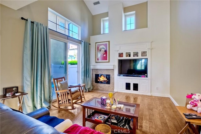66 Glenalmond Ln, Ladera Ranch, CA 92694 - living area with wood finished floors, a towering ceiling, and a tiled fireplace
