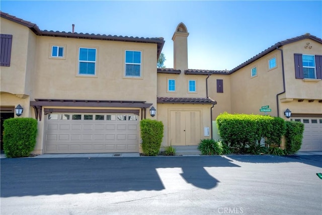 66 Glenalmond Ln, Ladera Ranch, CA 92694 - view of front of house featuring a chimney, a tiled roof, stucco siding, and an attached garage