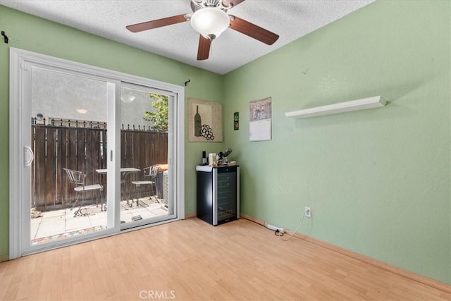 9100 Acacia Ave Unit 6, Fontana, CA 92335 - spare room with beverage cooler, wood finished floors, ceiling fan, and a textured ceiling