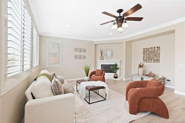 29851 Fox Creek Dr, Menifee, CA 92586 - living area with light wood-type flooring, ceiling fan, crown molding, a glass covered fireplace, and recessed lighting