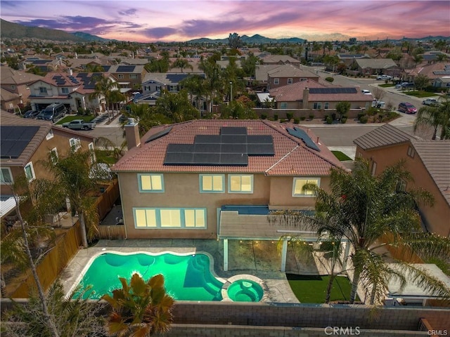 29851 Fox Creek Dr, Menifee, CA 92586 - back of house featuring a fenced backyard, solar panels, a residential view, and a tile roof
