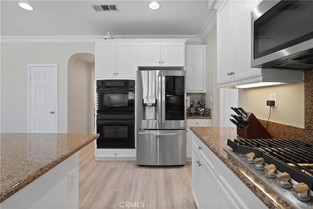 29851 Fox Creek Dr, Menifee, CA 92586 - kitchen with appliances with stainless steel finishes, ornamental molding, light stone countertops, arched walkways, and white cabinetry