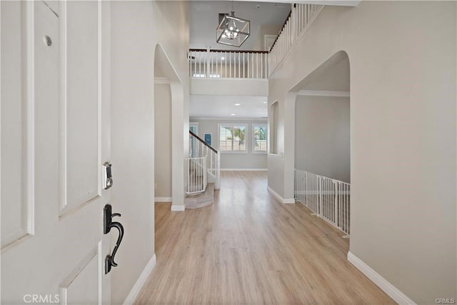 29851 Fox Creek Dr, Menifee, CA 92586 - foyer with wood finished floors, stairway, arched walkways, a chandelier, and a towering ceiling