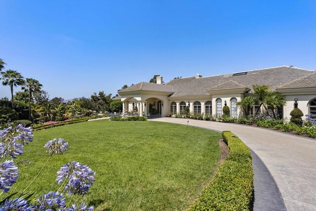 17124 Circa Oriente, Rancho Santa Fe, CA 92067 - view of front of house featuring a front yard, a chimney, and stucco siding