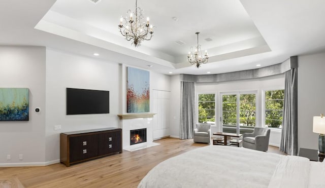 17124 Circa Oriente, Rancho Santa Fe, CA 92067 - bedroom with a chandelier, a raised ceiling, wood finished floors, a warm lit fireplace, and recessed lighting