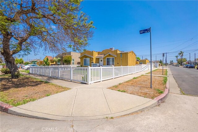 764 W 107th St, Los Angeles, CA 90044 - view of front facade with stucco siding and a fenced front yard