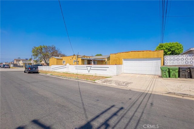 764 W 107th St, Los Angeles, CA 90044 - view of front of property with an attached garage, driveway, a residential view, and stucco siding