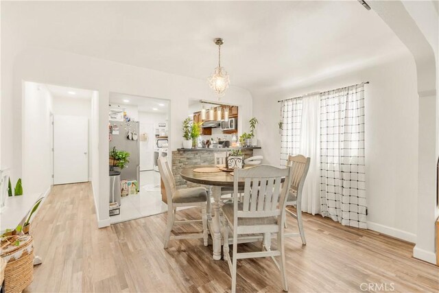 764 W 107th St, Los Angeles, CA 90044 - dining room featuring light wood finished floors and arched walkways