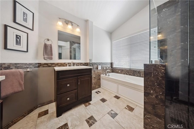 27628 Deerfield Ln, Valencia, CA 91354 - bathroom featuring vaulted ceiling, vanity, a bath, tile walls, and wainscoting