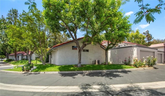1050 Windmill Ln, Oak Park, CA 91377 - view of side of home with stucco siding, an attached garage, and concrete driveway