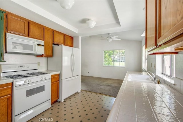 1050 Windmill Ln, Oak Park, CA 91377 - kitchen with white appliances, tile counters, light flooring, and ceiling fan