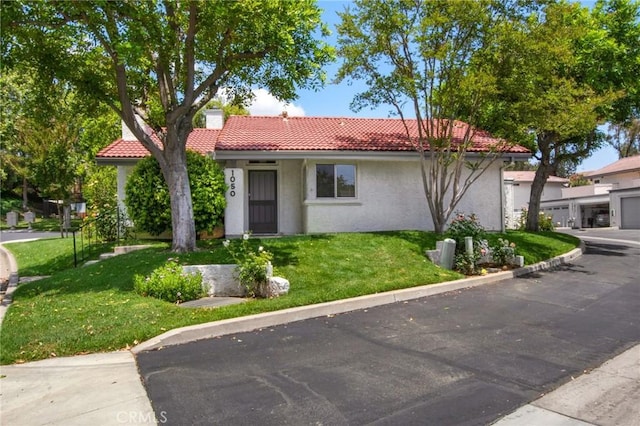 1050 Windmill Ln, Oak Park, CA 91377 - view of front of home featuring a tile roof, a front lawn, and stucco siding