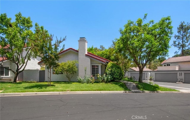 1050 Windmill Ln, Oak Park, CA 91377 - view of front of home featuring stucco siding, a garage, and a chimney