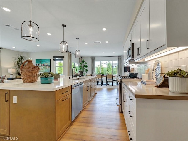 17151 Kent St, Hesperia, CA 92345 - kitchen with stainless steel appliances, light wood-type flooring, a large island, tasteful backsplash, and recessed lighting