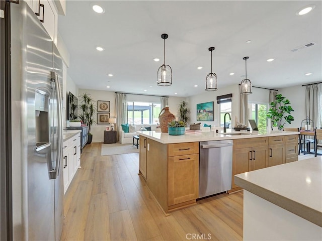 17151 Kent St, Hesperia, CA 92345 - kitchen with stainless steel appliances, open floor plan, recessed lighting, light countertops, and light wood-style floors