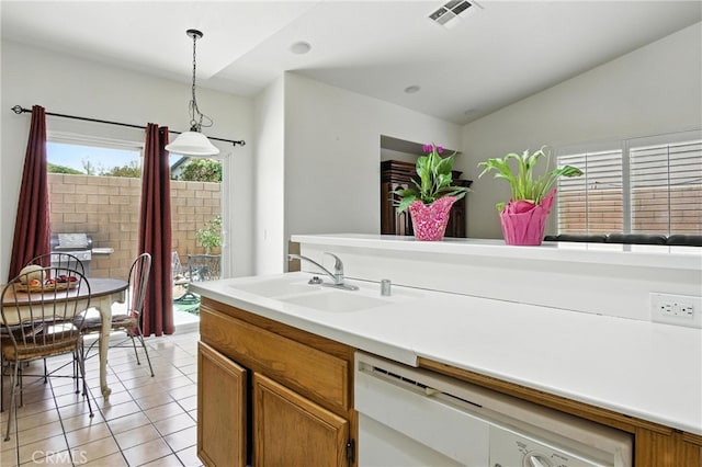 13525 Evanston St, Victorville, CA 92392 - kitchen featuring white dishwasher, hanging light fixtures, brown cabinets, light tile patterned floors, and light countertops
