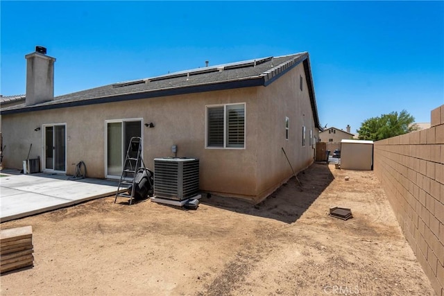 13525 Evanston St, Victorville, CA 92392 - rear view of house with a fenced backyard, a patio, a chimney, stucco siding, and solar panels