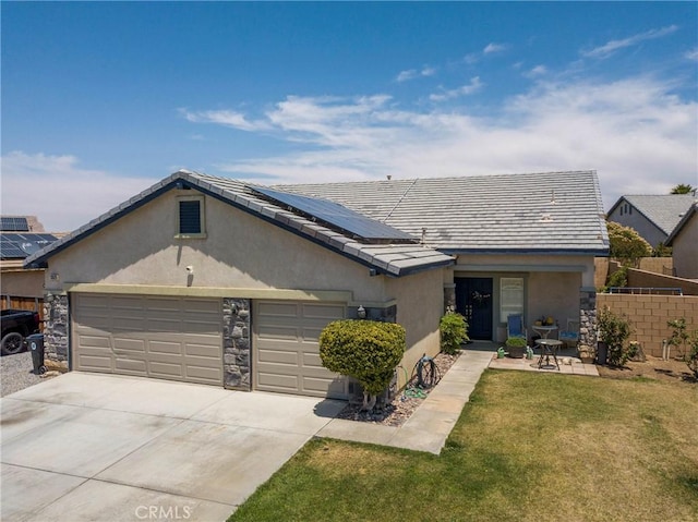 13525 Evanston St, Victorville, CA 92392 - ranch-style house featuring stucco siding, a garage, concrete driveway, roof mounted solar panels, and stone siding