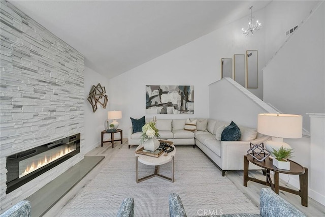 39 Cape Cod, Irvine, CA 92620 - living room featuring high vaulted ceiling, a stone fireplace, a chandelier, wood finished floors, and stairway