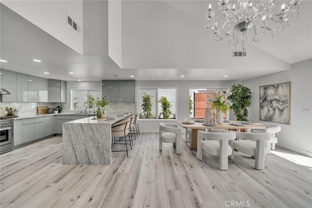 39 Cape Cod, Irvine, CA 92620 - kitchen featuring gray cabinetry, modern cabinets, a towering ceiling, a breakfast bar, and recessed lighting