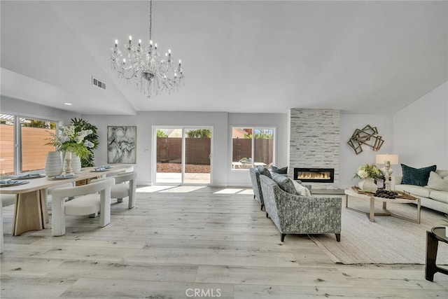 39 Cape Cod, Irvine, CA 92620 - living room featuring lofted ceiling, light wood-style floors, a fireplace, and a chandelier