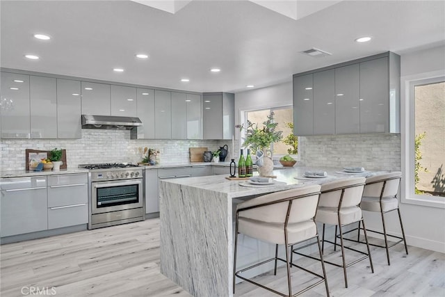 39 Cape Cod, Irvine, CA 92620 - kitchen with gray cabinetry, high end stainless steel range oven, modern cabinets, under cabinet range hood, and recessed lighting