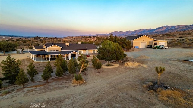35655 52nd St E, Palmdale, CA 93552 - view of front of home with a mountain view, a garage, and dirt driveway