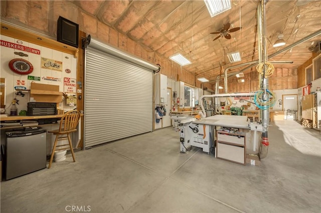 35655 52nd St E, Palmdale, CA 93552 - garage with refrigerator, a workshop area, and ceiling fan