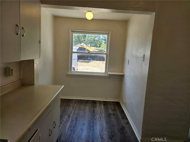 26483 9th St, Highland, CA 92346 - unfurnished dining area with dark wood-style floors and baseboards