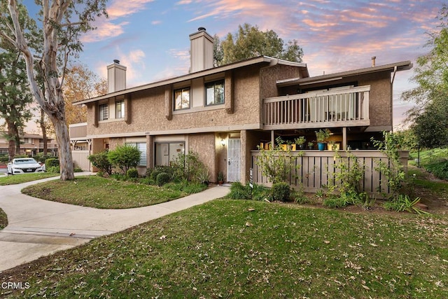 4448 Lubbock Dr Unit C, Simi Valley, CA 93063 - view of front of property with a chimney, a front lawn, stucco siding, and a balcony