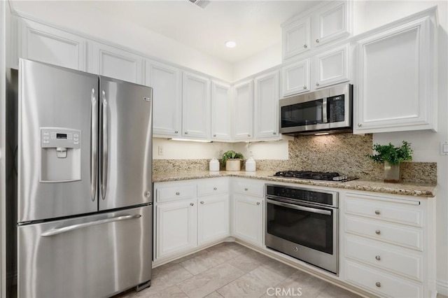 5527 Patricia Way, Yorba Linda, CA 92887 - kitchen featuring appliances with stainless steel finishes, white cabinetry, light stone counters, and tasteful backsplash