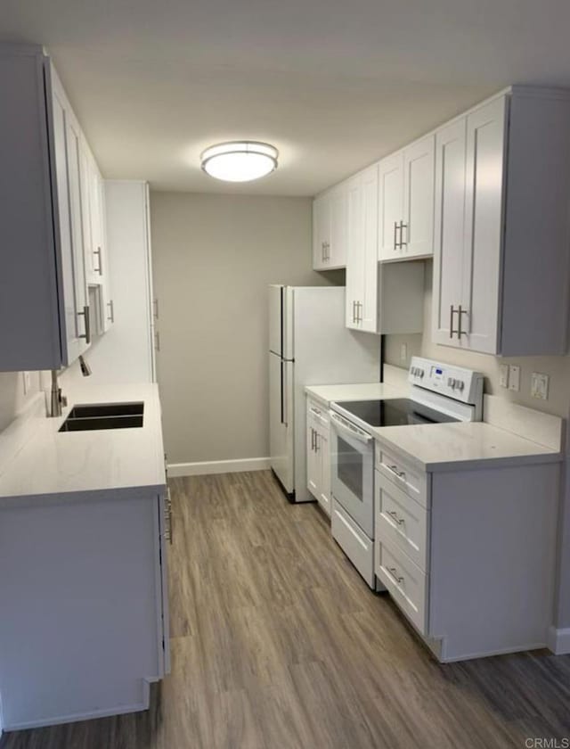 2330 Hosp Way Unit 303, Carlsbad, CA 92008 - kitchen with white range with electric cooktop, wood finished floors, light countertops, and white cabinets