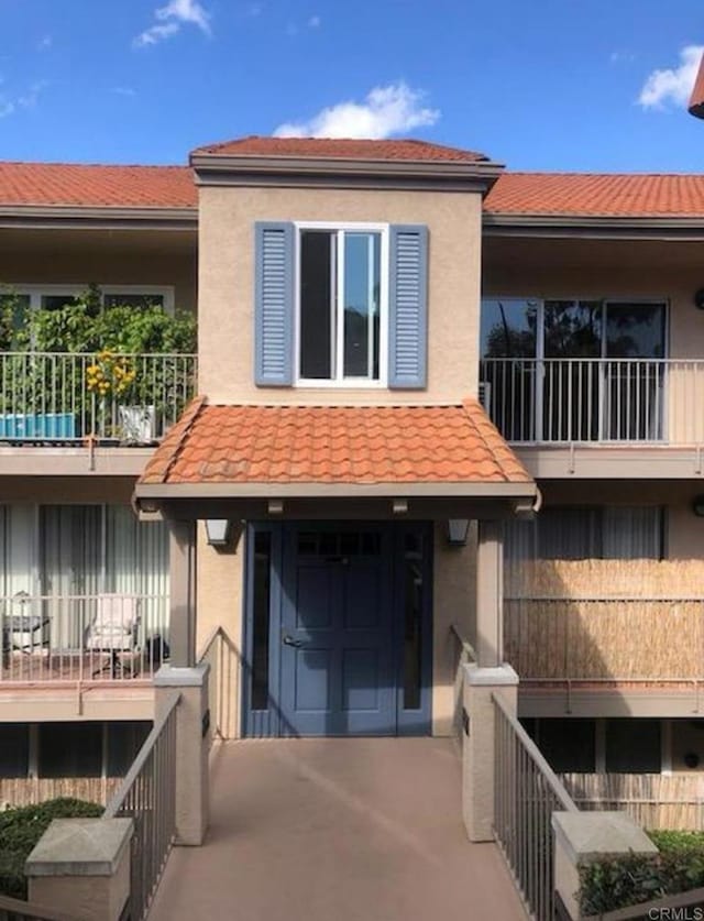 2330 Hosp Way Unit 303, Carlsbad, CA 92008 - view of front of house featuring a balcony, stucco siding, and a tiled roof