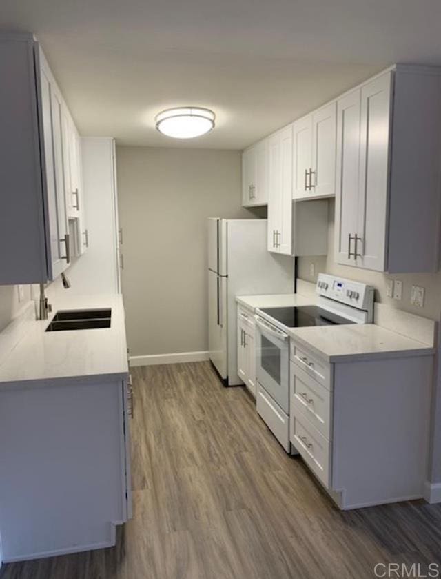2330 Hosp Way Unit 303, Carlsbad, CA 92008 - kitchen featuring white electric stove, wood finished floors, light countertops, and white cabinetry