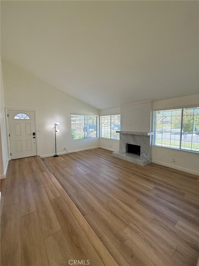 3964 Hibbert Ct, Simi Valley, CA 93063 - unfurnished living room featuring light wood-style floors, healthy amount of natural light, vaulted ceiling, and a high end fireplace