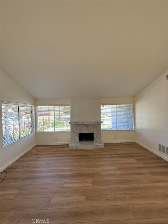 3964 Hibbert Ct, Simi Valley, CA 93063 - unfurnished living room featuring vaulted ceiling, light wood-type flooring, plenty of natural light, and a high end fireplace