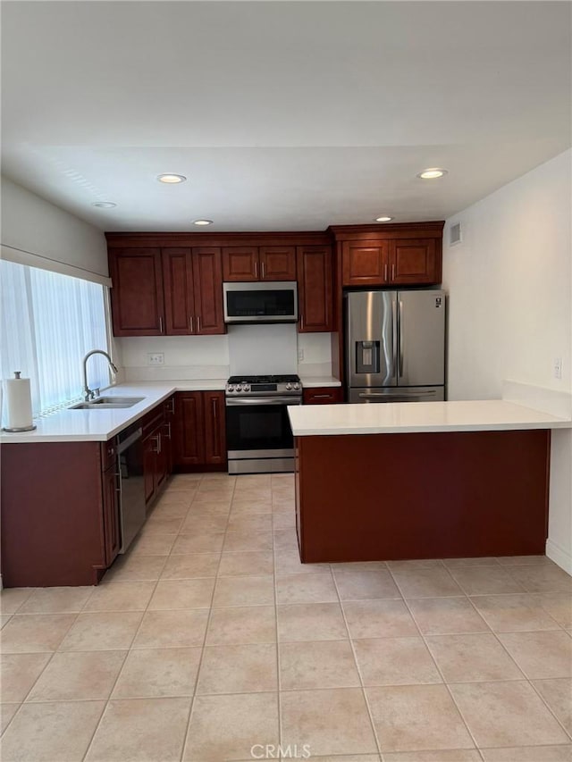 3964 Hibbert Ct, Simi Valley, CA 93063 - kitchen with appliances with stainless steel finishes, light countertops, a peninsula, recessed lighting, and light tile patterned floors