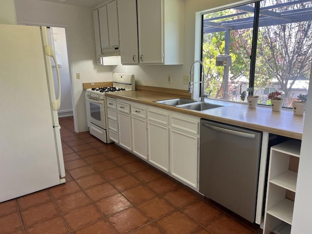 1404 Lombard St, Vista, CA 92084 - kitchen with white appliances, dark tile patterned floors, light countertops, white cabinetry, and under cabinet range hood