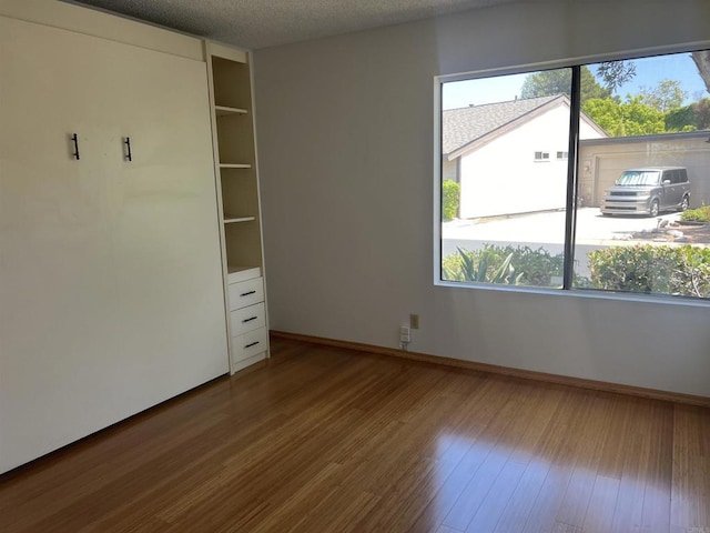 1404 Lombard St, Vista, CA 92084 - unfurnished bedroom featuring multiple windows, wood finished floors, and a textured ceiling