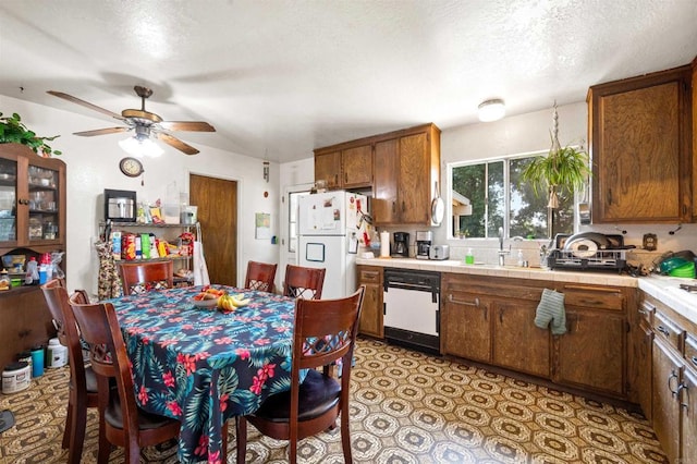 16805 Duckworth Ave, Riverside, CA 92504 - kitchen featuring white appliances, brown cabinets, a ceiling fan, a textured ceiling, and tile counters