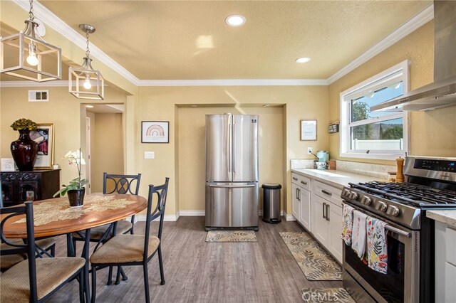 3704 La Sierra Ave, Riverside, CA 92505 - kitchen with stainless steel appliances, wall chimney range hood, wood finished floors, light countertops, and white cabinets