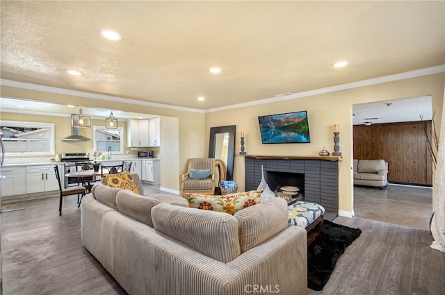 3704 La Sierra Ave, Riverside, CA 92505 - living room featuring a fireplace, light wood-style flooring, recessed lighting, and crown molding