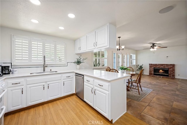 19177 White Dove Ln, Riverside, CA 92508 - kitchen featuring stainless steel dishwasher, a ceiling fan, a peninsula, a fireplace, and light countertops