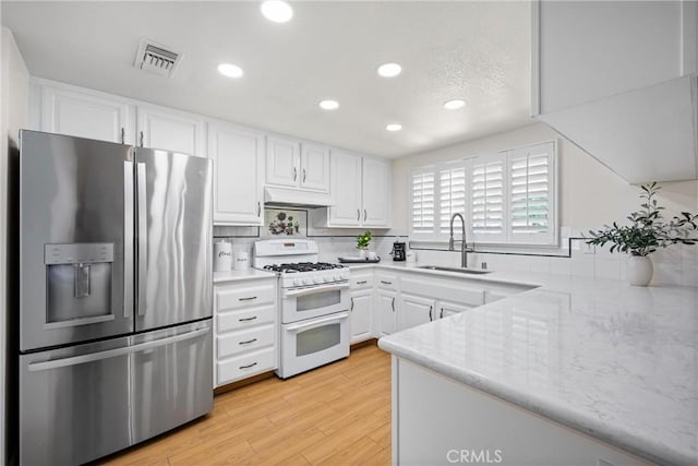 19177 White Dove Ln, Riverside, CA 92508 - kitchen with stainless steel refrigerator with ice dispenser, range with two ovens, white cabinetry, recessed lighting, and backsplash