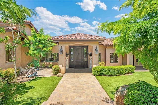 1935 Granite Hills Dr, El Cajon, CA 92019 - view of exterior entry featuring a tile roof, a yard, and stucco siding
