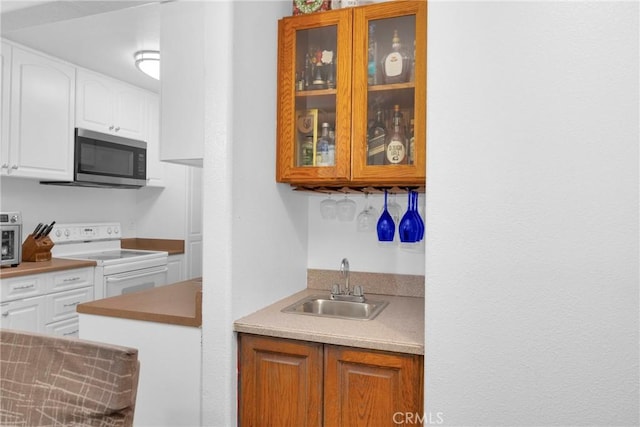 382 S Miraleste Dr Unit 450, San Pedro, CA 90732 - kitchen featuring electric stove, stainless steel microwave, glass insert cabinets, and white cabinetry
