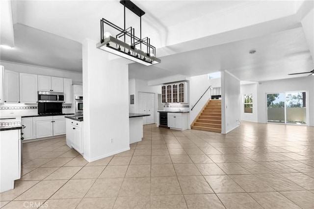 22870 Trigger St, Chatsworth, CA 91311 - kitchen with stainless steel appliances, open floor plan, decorative backsplash, light tile patterned floors, and dark countertops