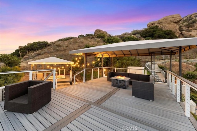 22870 Trigger St, Chatsworth, CA 91311 - deck at dusk with a gazebo and an outdoor living space with a fire pit